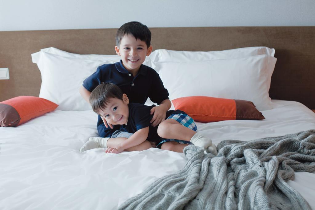 Fraser Place Robertson Walk Singapore Exteriör bild Two children playing on a bed